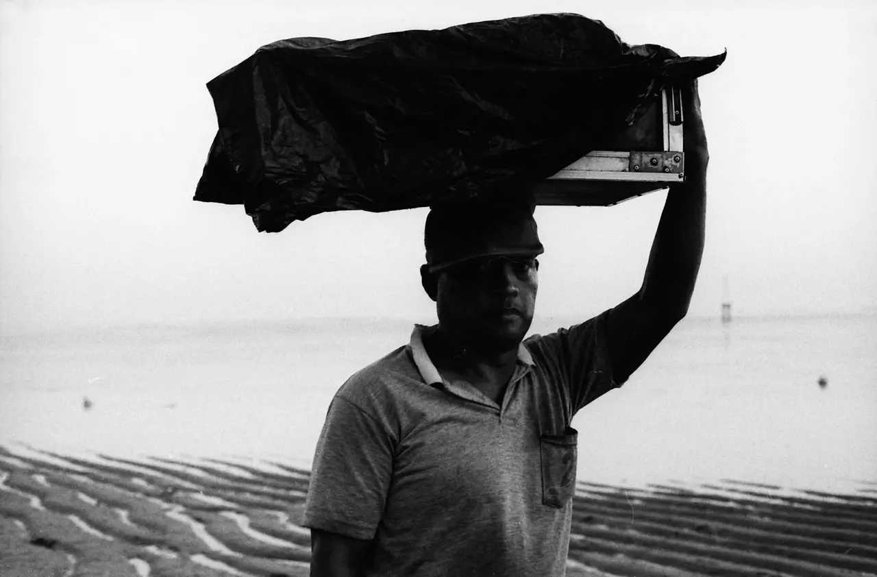 A street portrait of a food vendor in the fading light at Sanur Beach, Bali